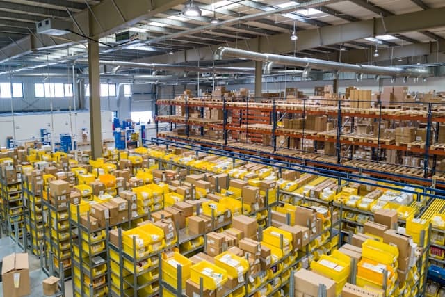 A wide view of a distribution warehouse stacked with pallets