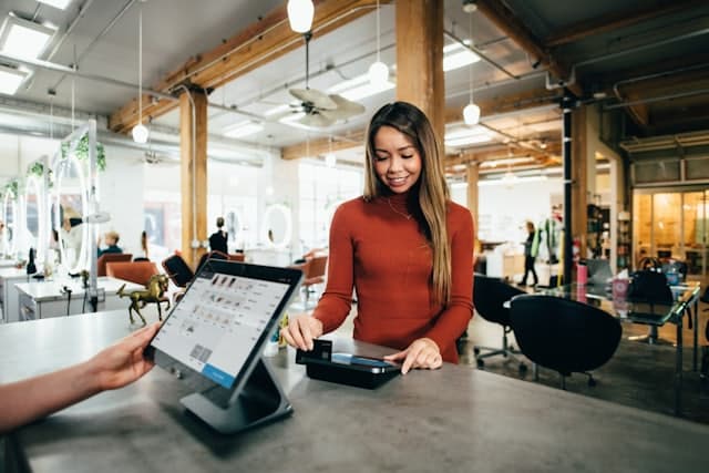 A shop assistant taking a card payment at a store counter